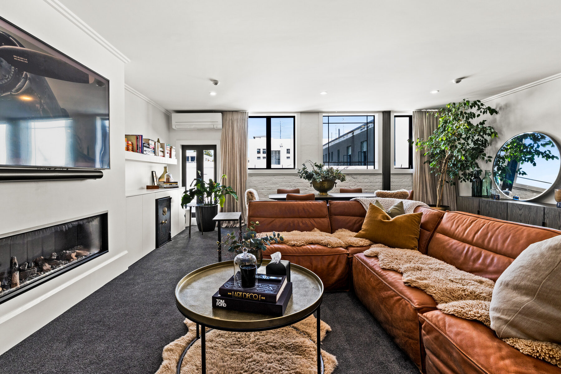 Luxury apartment living room with leather sofas and fireplace — executive accommodation Napier